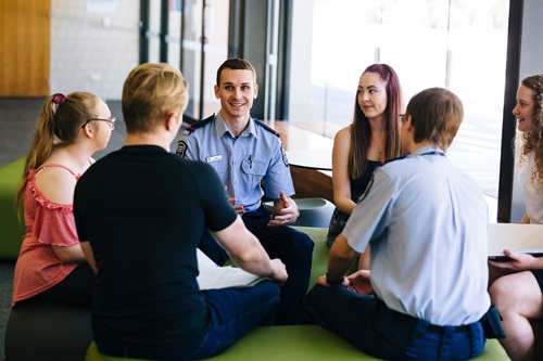 Photo: a group of students chatting to a police officer