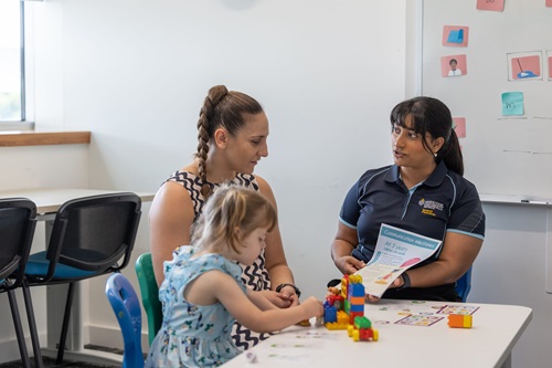 Photo: a Speech Pathology student in / Images by Roslyn Budd – Budd Photography a treatment session with a woman and a child / Images by Roslyn Budd – Budd Photography
