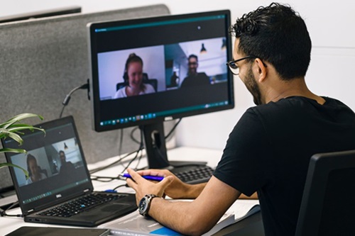 Photo: a student sitting at a computer on a video call